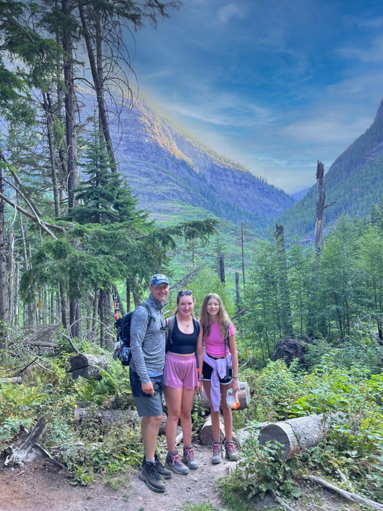 Hikers on Avalanche Lake Trail with mountains in background