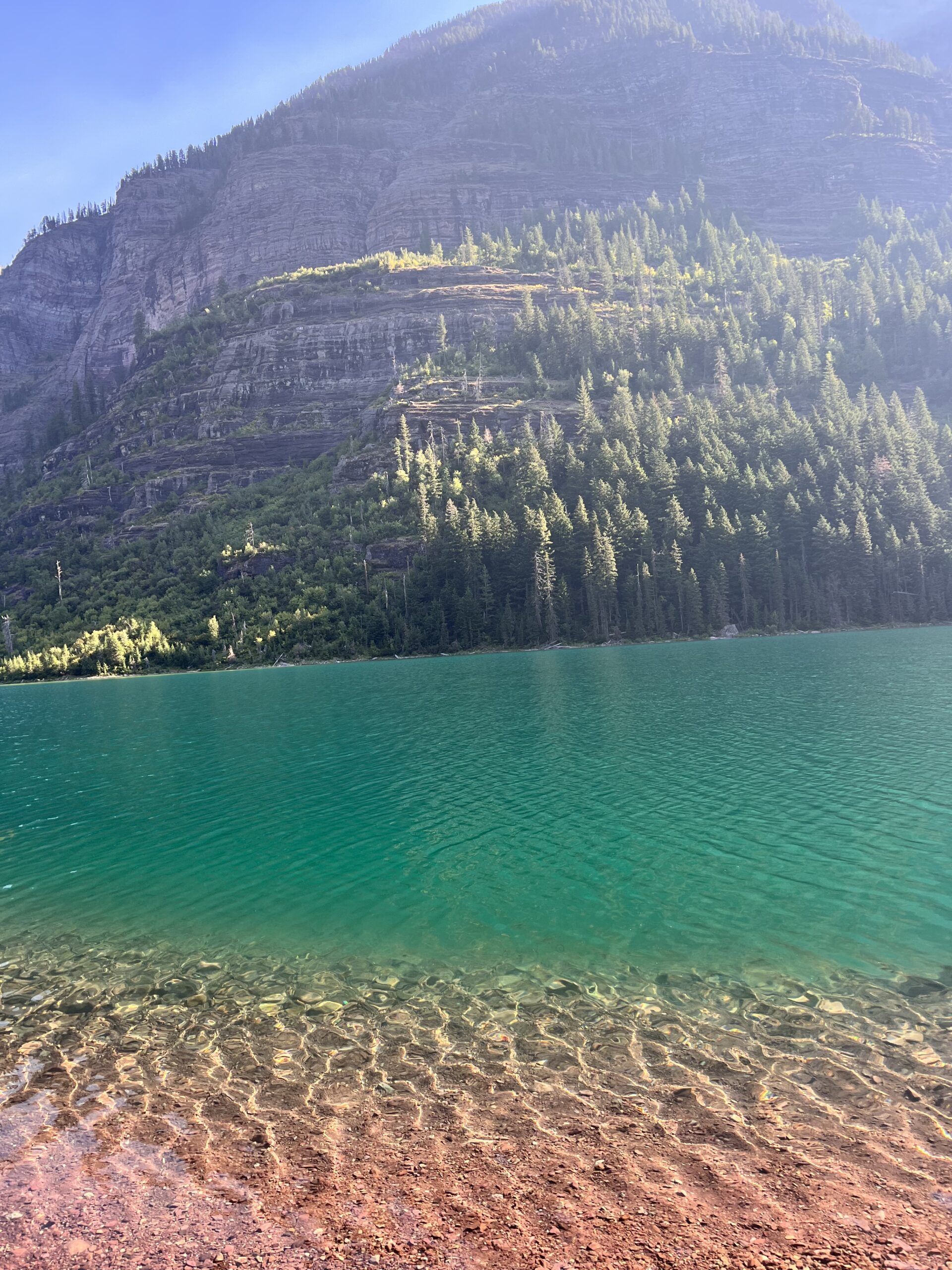 Bright teal green water of Avalanche Lake in Glacier National Park