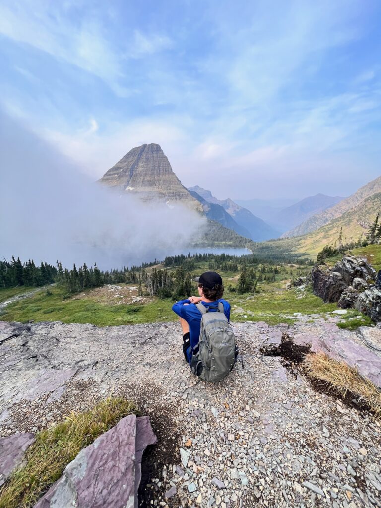 Man looking at fog covering Hidden Lake in Glacier National Park