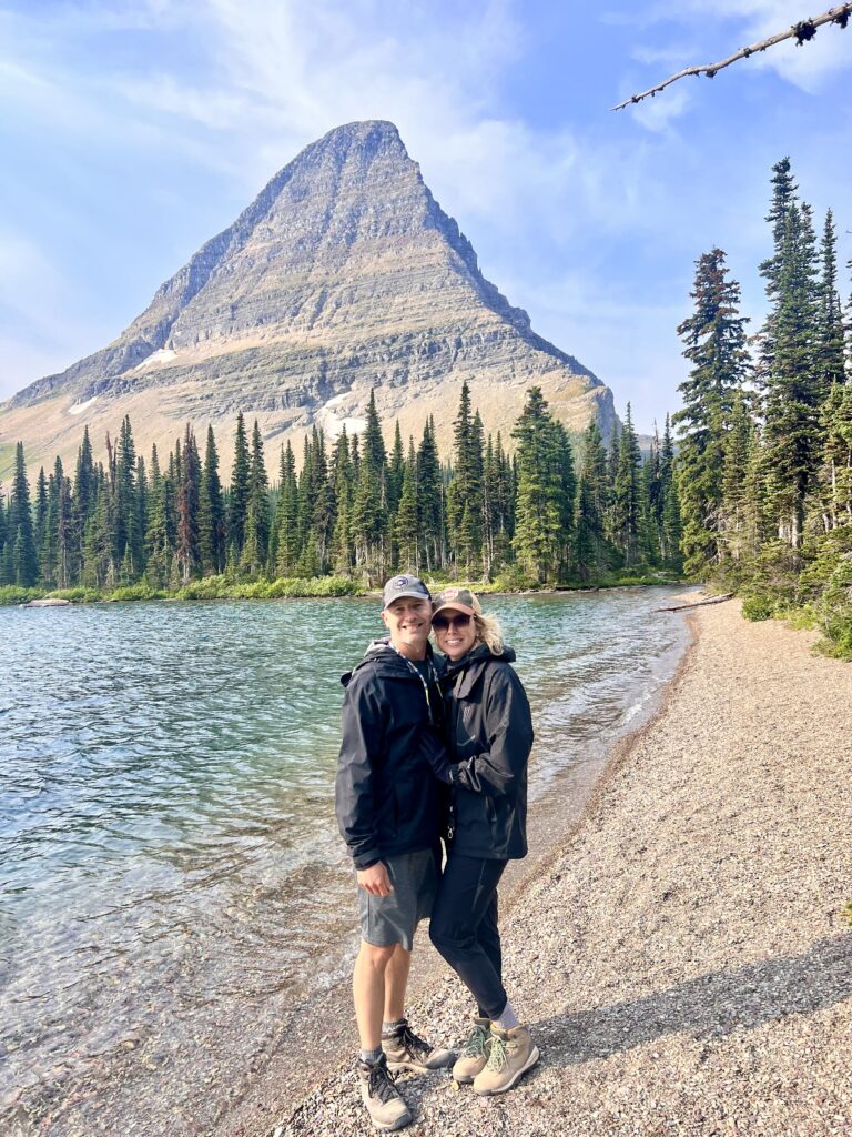 Couple standing on beach at Hidden Lake with bearcat mountain behind them.