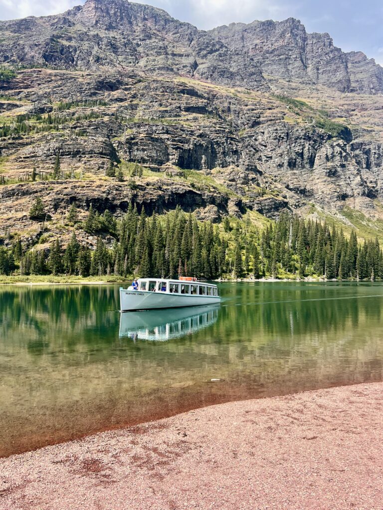 Boat driving across emerald green Lake Josephine