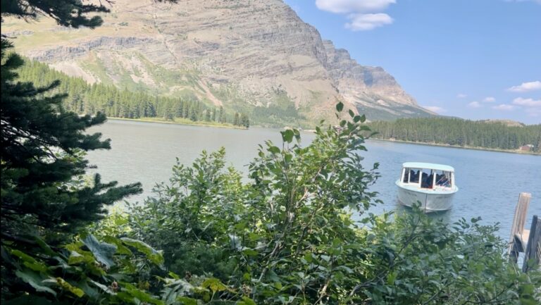 Boat shuttle arriving at dock in Swiftcurrent Lake