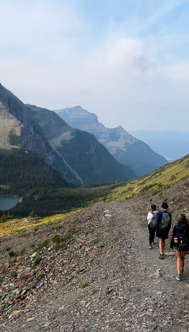 Hikers on Hidden Lake Trail with mountains in background